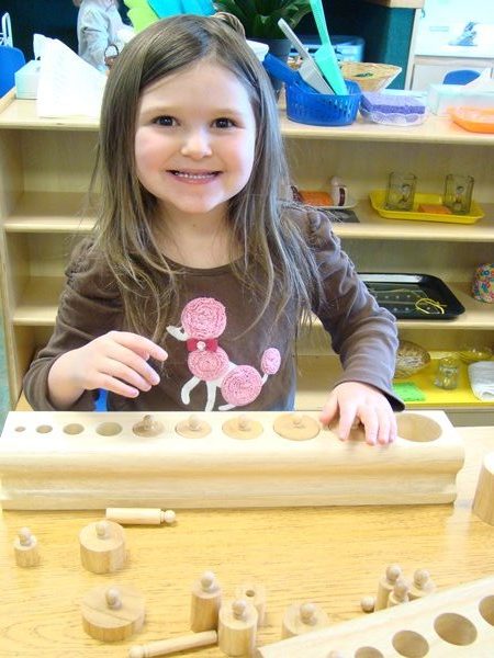 smiling montessori girl playing with manipulatives at Skipwith Academy